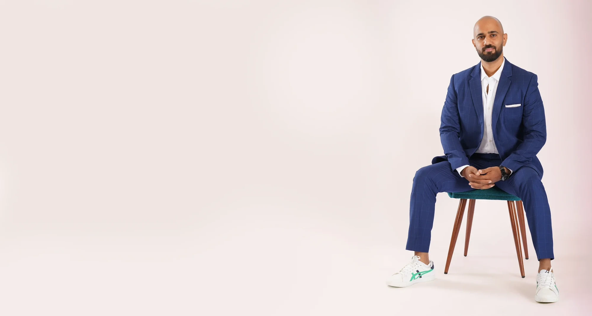 Tony Puthedan seated in a navy suit